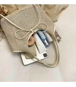 Gros plan du sac fourre-tout tissé beige avec nœud montrant sa grande capacité