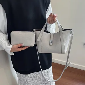 Ensemble sac seau et pochette gris clair texture litchi avec boucle argentée et bandoulière