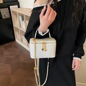 Elegant white square box bag with gold chain strap and heart charm pendant