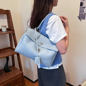 Sac à bandoulière en similicuir bleu clair avec texture litchi et fermoir rotatif argent