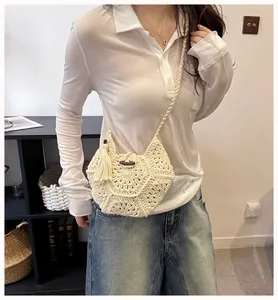 Détail d'un sac au crochet fait main avec bouton vintage en bois et pompons doux