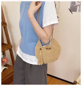 Détail du sac bohème en paille avec texture évidée, longues franges et fermoir en bois