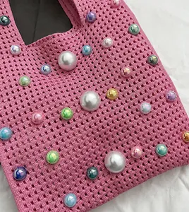 Vue détaillée du sac cabas en tricot rose orné de perles irisées multicolores