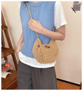 Gros plan détaillé du sac tissé main avec pompons à franges et bouton en bois naturel