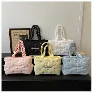 Detailed macro view of quilted puffer tote bags with ribbon bows and ruffle handles