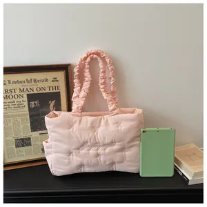 Detailed close-up of pink quilted tote bag with pleated handle and side storage pocket