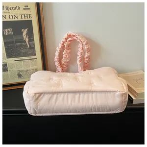 Detailed view of pink puffer tote bag with ruffled handles and delicate bow embroidery