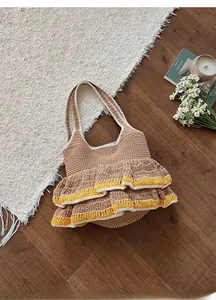 Macro view of a brown knit tote bag featuring vibrant yellow and white ruffled edges