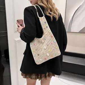 Détail du sac fourre-tout en tricot beige avec perles colorées et poignée en perles blanches