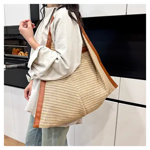 Close-up detail of the woven tote bag showing natural straw texture and leather straps