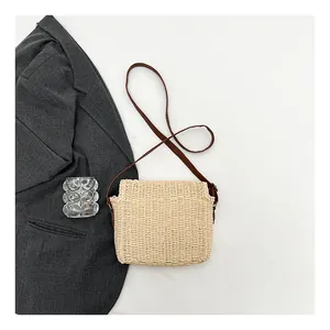 Detailed weave pattern on beige straw crossbody bag with brown leather strap