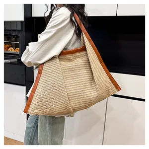 Close-up of the woven straw texture and premium brown leather trim on the tote bag