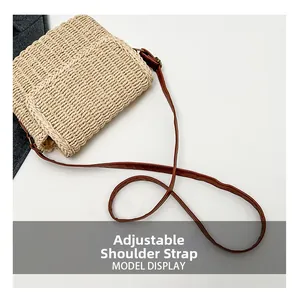Detail shot of the beige straw shoulder bag showing the adjustable brown leather strap