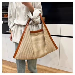 Detailed view of beige woven tote bag with brown leather straps shown on a model