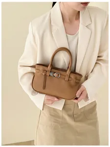Détail d'un sac à main marron en cuir grainé avec boucles à anneaux argentés