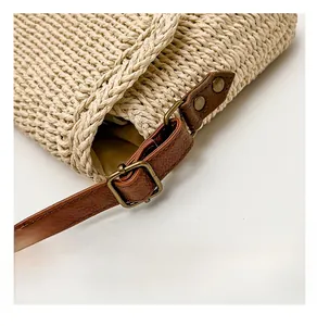 Macro shot of vintage bronze hardware and brown leather strap on a straw woven bag