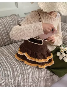 Detail of vintage-style crochet tote bag with brown knit body and yellow ruffle trim
