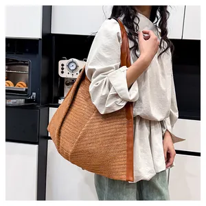 Detail of a large woven leopard print tote bag with brown faux leather handles and edges