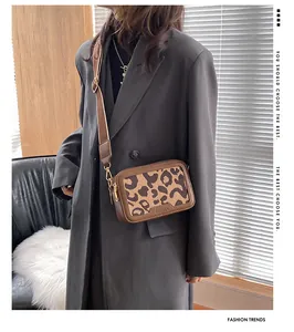 Dettaglio della borsa a tracolla leopardata con tracolla larga e logo a rilievo