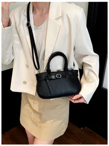 Détail du sac à main noir à texture litchi avec boucles argentées et poignée