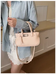 Détail du sac à main en cuir rose texturé porté avec une tenue d'été décontractée