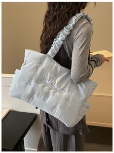 Close-up of quilted puff tote bag in light blue with bow detail and ruched strap