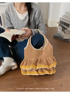 Detail of a large capacity khaki knit tote bag with double ruffle hem and yellow piping