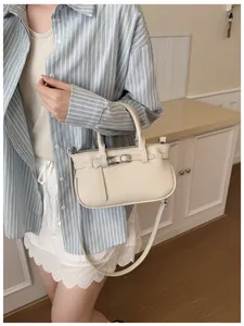 Détail du sac à main blanc cassé en cuir grainé avec sangle décorative et double poignée
