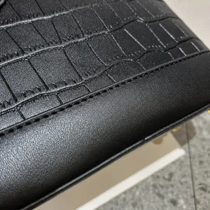 Detailed macro view of black crocodile pattern leather and premium stitching on bag