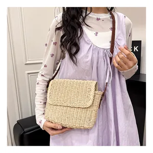 Detailed straw texture of beige woven crossbody bag with brown leather strap detail