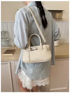 Détail du sac à main beige en cuir grainé avec boucle métallique et bandoulière