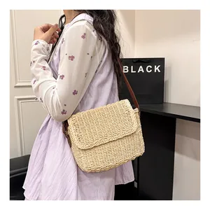 Detail of hand-woven straw shoulder bag with vintage texture and brown leather strap