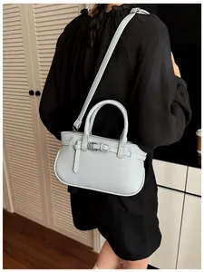 Détail du sac à main bleu clair avec texture litchi et boucle argentée élégante