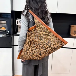 Large leopard print tote bag with brown leather trim shown in a stylish home setting