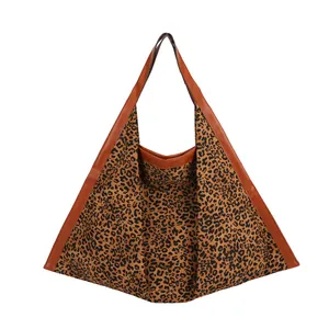 Large leopard print tote bag with brown leather handles on a clean white background