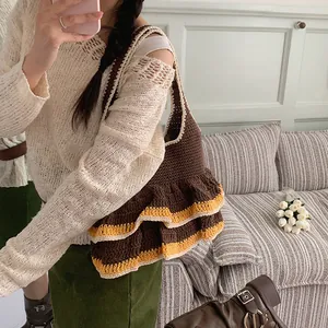 Brown crochet knit tote bag with yellow ruffled edge ruffle detail on grey background