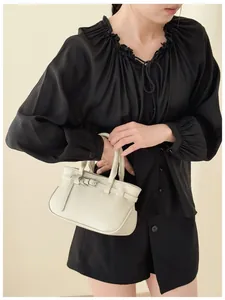 Détail du sac à main en cuir grainé blanc avec boucle argentée et décor de ceinture