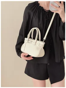 Vue détaillée du sac à bandoulière crème avec texture litchi et boucle métallique