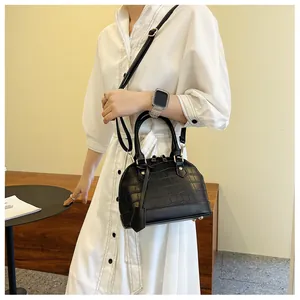 Detailed view of the black crocodile pattern shell bag with golden hardware accents