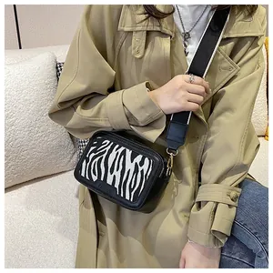 Dettaglio borsa a tracolla motivo zebra con ampia cinghia e logo moda goffrato