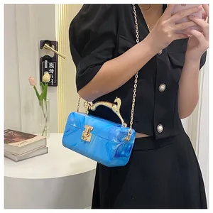 Detail of blue marble acrylic handbag featuring a golden horse handle and snap lock