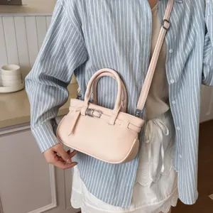 Sac à main trapèze en cuir rose avec texture litchi, boucle argentée et bandoulière