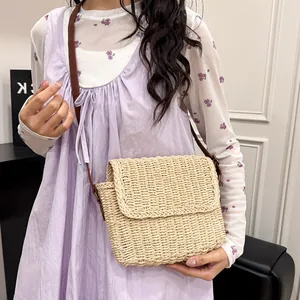 Minimalist straw crossbody bag for women with brown shoulder strap and woven texture