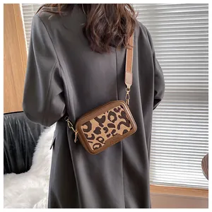 Dettaglio della borsa a tracolla vintage leopardata con scritta fashion e finiture dorate