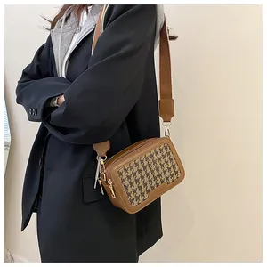 Dettaglio borsa a tracolla vintage pied-de-poule con pelle marrone e fibbie dorate