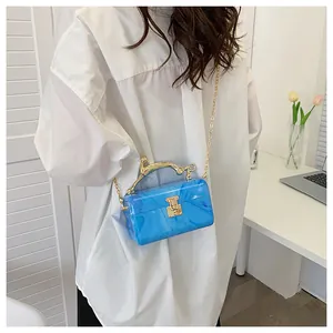 Detail of blue marble acrylic box bag featuring a golden animal-shaped handle and chain