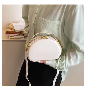 Gros plan d'un sac bandoulière blanc demi-lune avec double fermeture éclair dorée