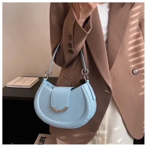 Détail du sac sous le bras en forme de croissant bleu clair avec boucle argentée