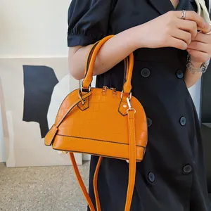 Vibrant orange crocodile pattern shell bag with top handles and shoulder strap