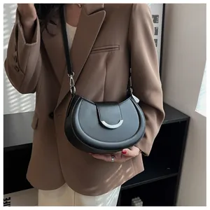 Détail du sac selle en similicuir noir en forme de croissant avec boucle argentée chic